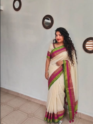 Model in a cream saree with pink and green border